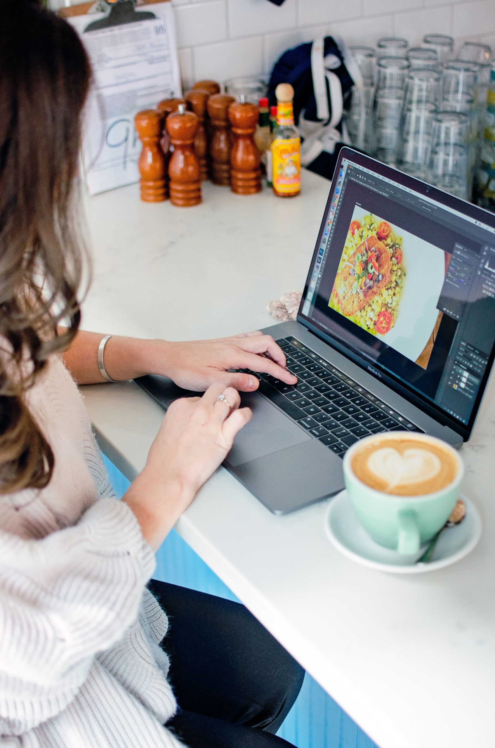 woman working on computer editing photos at a coffee shop