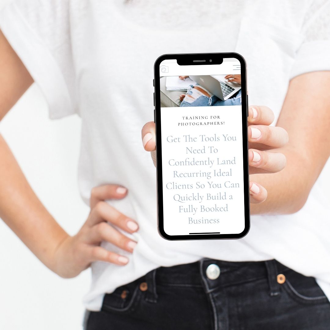 woman holding phone with a screenshot of the brand photographers blueprint course website page that says training for photographers! get the tools you need to confidently land recurring ideal clients so you can quickly build a fully booked business